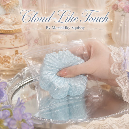 Hand squeezing a soft pastel blue blossom squishy inside a plastic bag, showing its cloud-like touch.