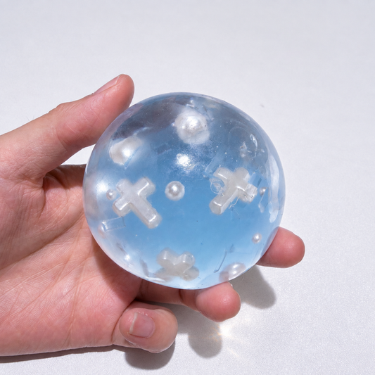 Blue translucent ball showing cross-shaped inclusions and pearl accents
