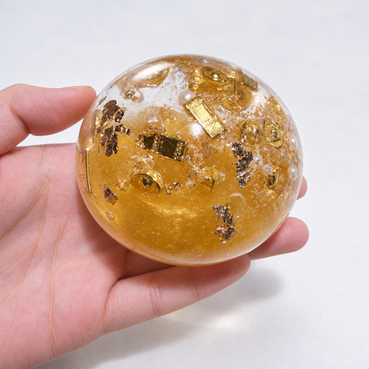 Close view of gold-tone decorative pieces and pearls inside the amber ball
