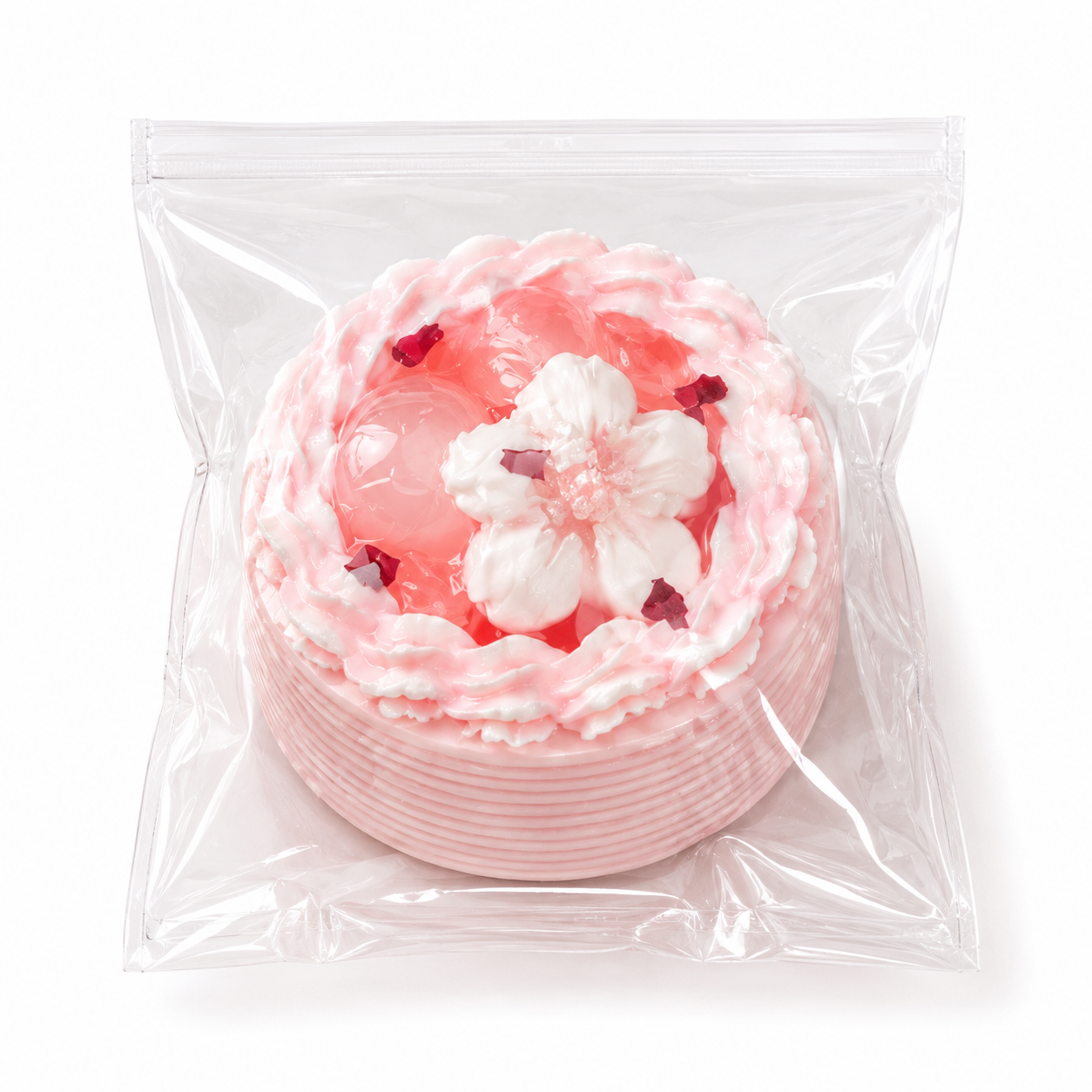 Pink sakura mini cake squishy stress toy inside a clear plastic ziplock packaging on a white background.