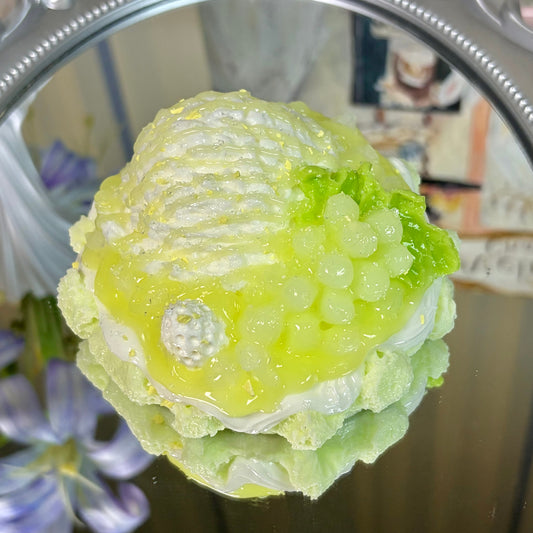 Green grape and melon cake squishy with glossy syrup finish and translucent fruit balls, displayed on a mirror with soft reflection