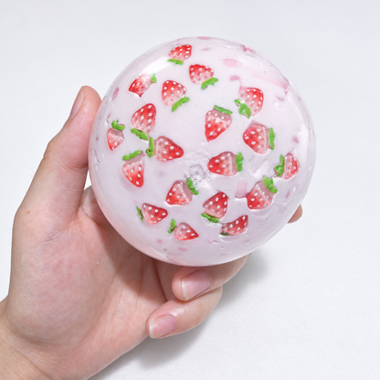 Translucent pink sensory squishy ball with visible resin strawberry-shaped pieces; Strawberry Milkshake handmade sensory squishy ball, product photo 1
