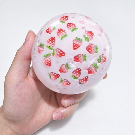 Translucent pink sensory squishy ball with visible resin strawberry-shaped pieces; Strawberry Milkshake handmade sensory squishy ball, product photo 1