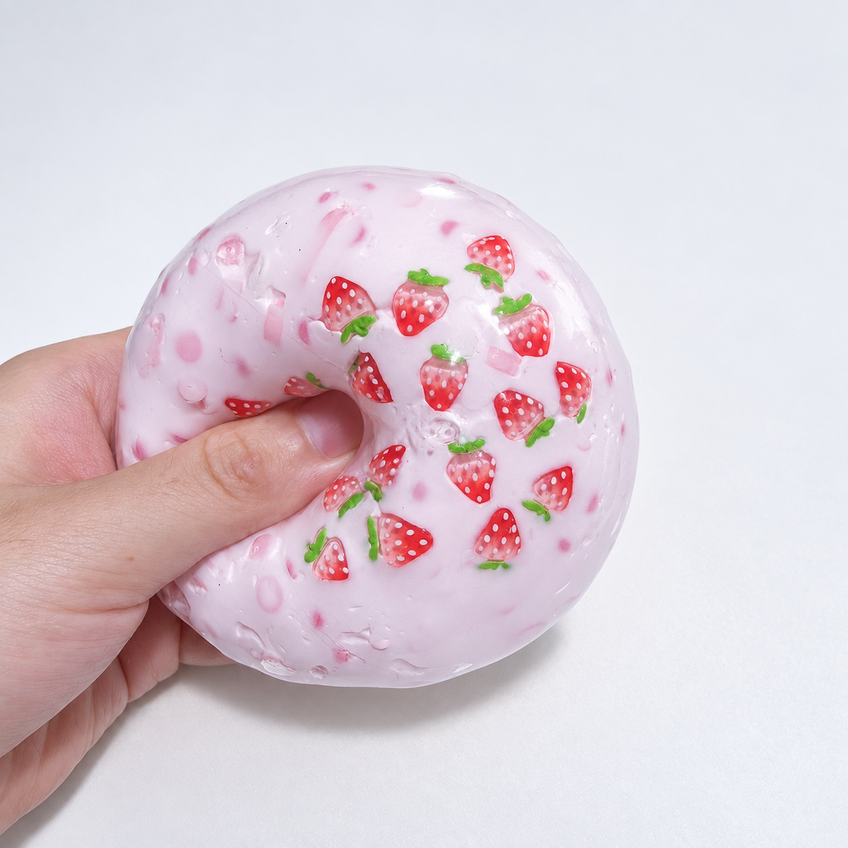 Translucent pink sensory squishy ball with visible resin strawberry-shaped pieces; Strawberry Milkshake handmade sensory squishy ball, product photo 3