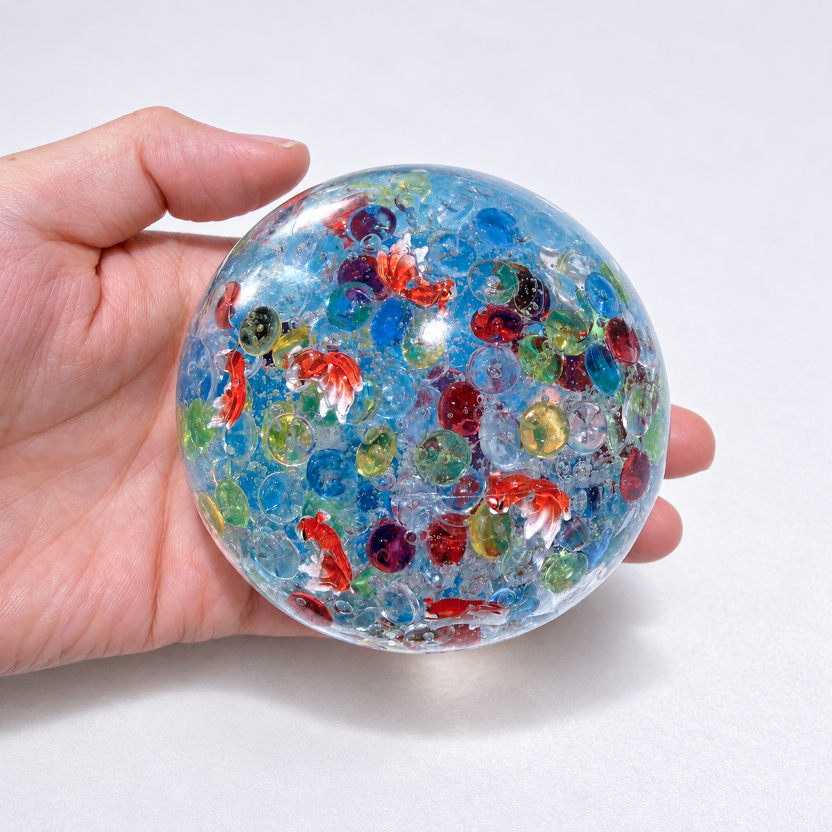 Blue translucent sensory squishy ball with colorful resin fish-shaped details; Floating Light Fish handmade sensory squishy ball, product photo 3
