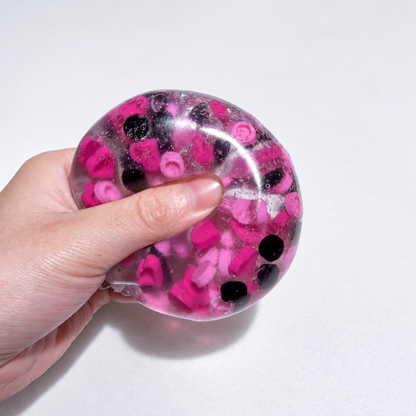 Translucent pink sensory squishy ball with contrasting dark and pink resin decorative pieces; Pink Black Sweetheart handmade sensory squishy ball, product photo 4
