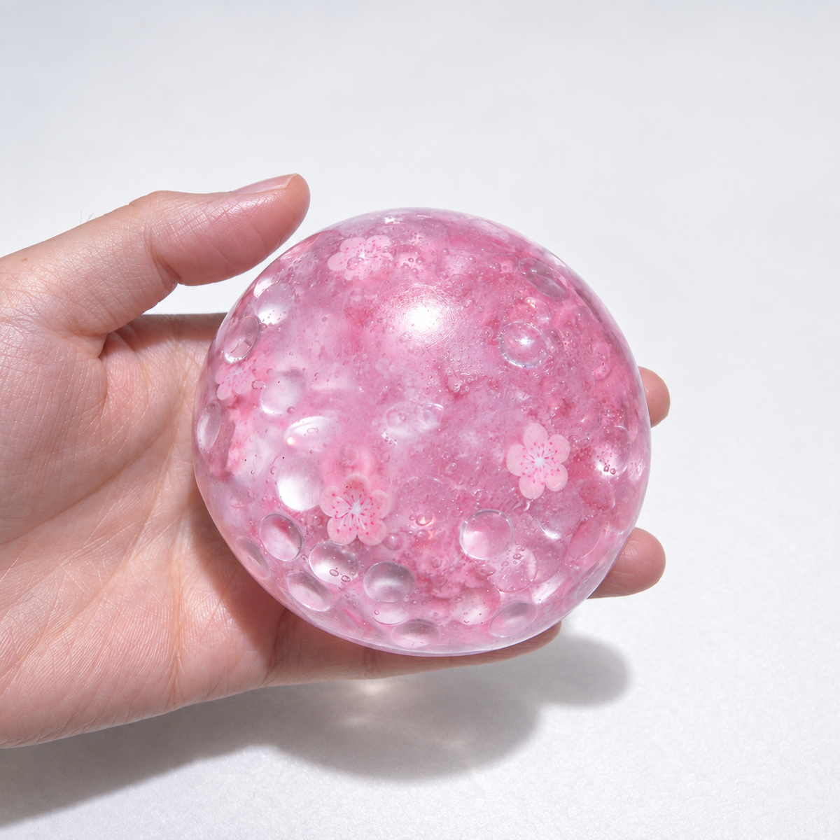 Pink translucent sensory squishy ball with resin sakura blossom details and beads; Sakura Dream handmade sensory squishy ball, product photo 4