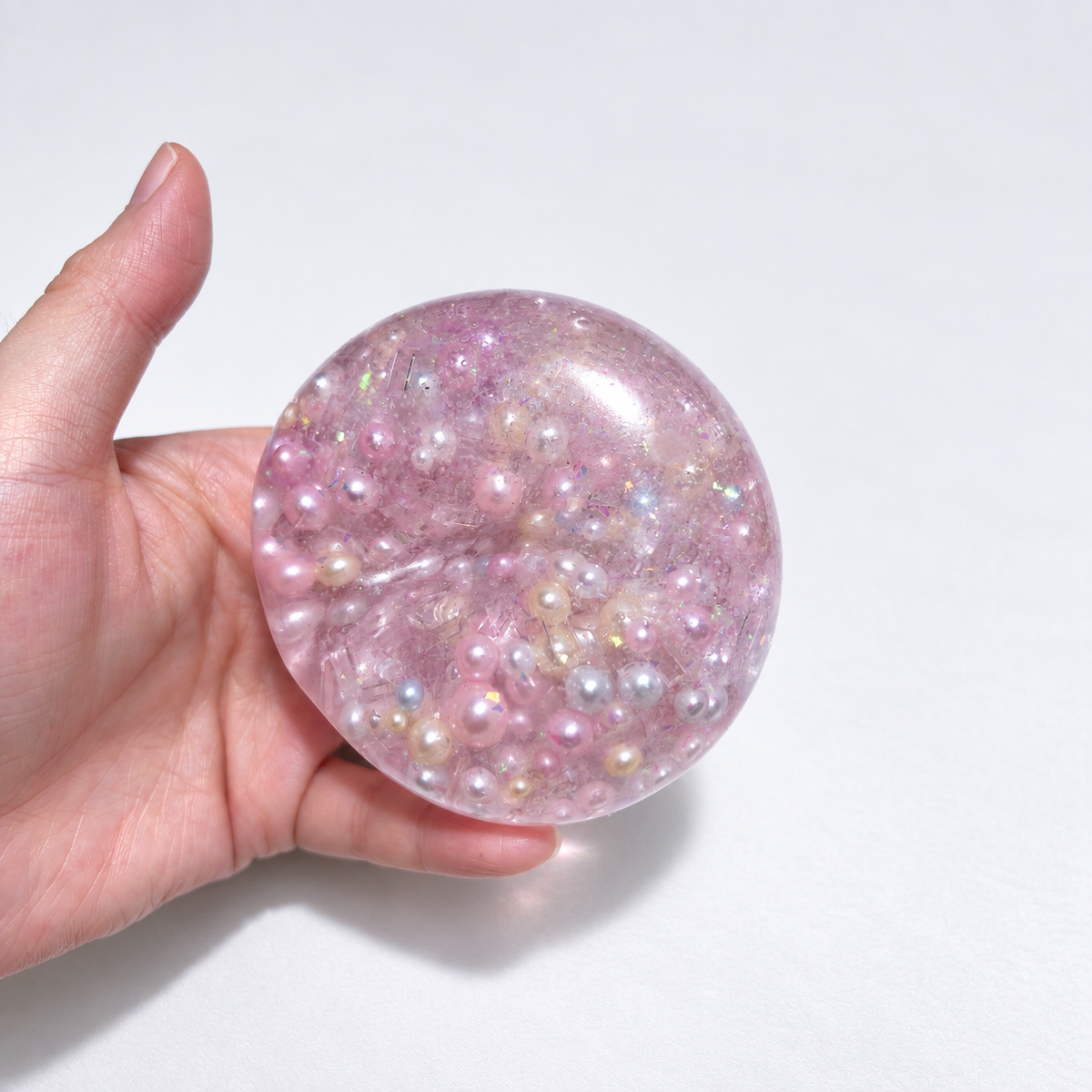 Pink translucent sensory squishy ball with resin pearl-like beads and iridescent details; Mermaid Pink Pearl handmade sensory squishy ball, product photo 1