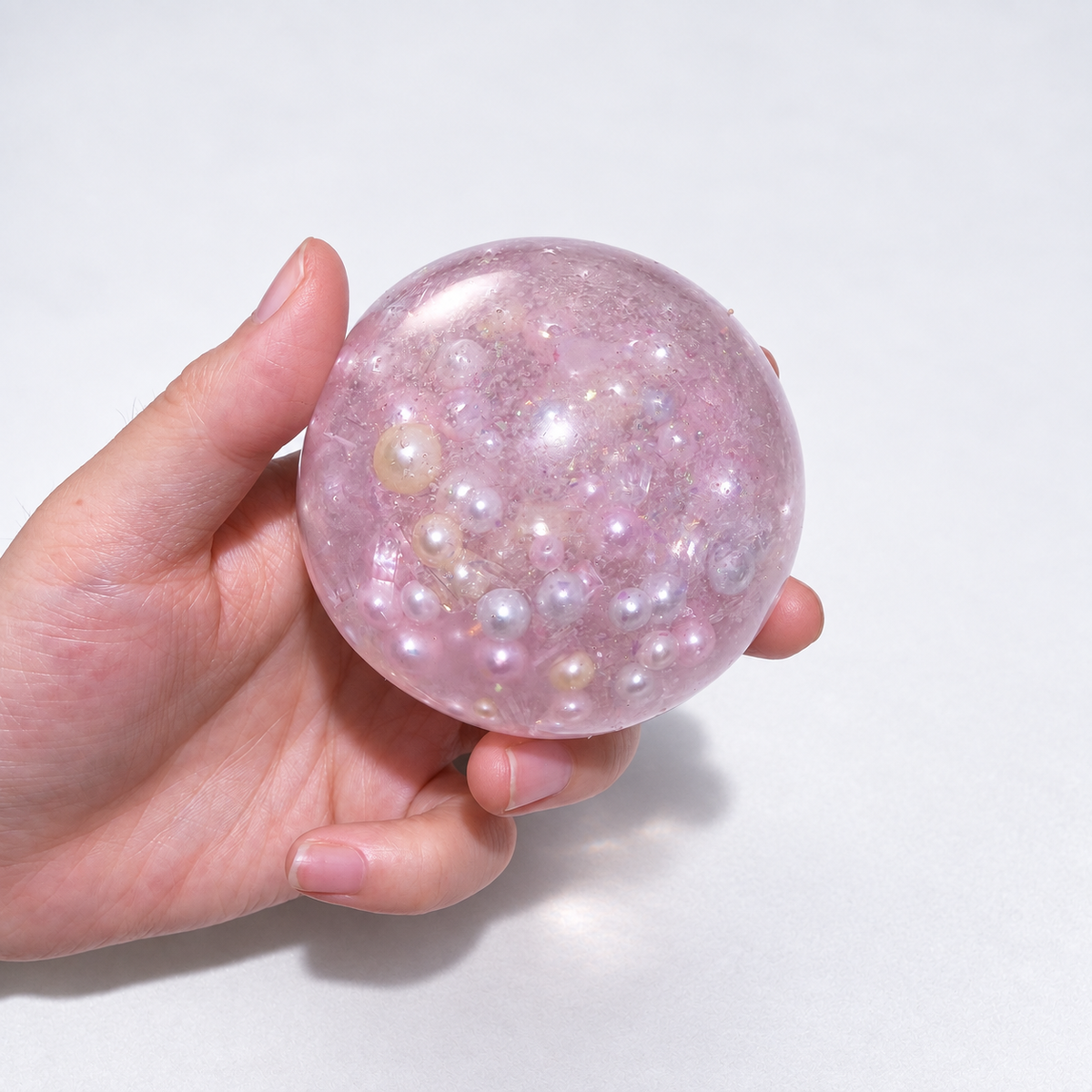 Pink translucent sensory squishy ball with resin pearl-like beads and iridescent details; Mermaid Pink Pearl handmade sensory squishy ball, product photo 2