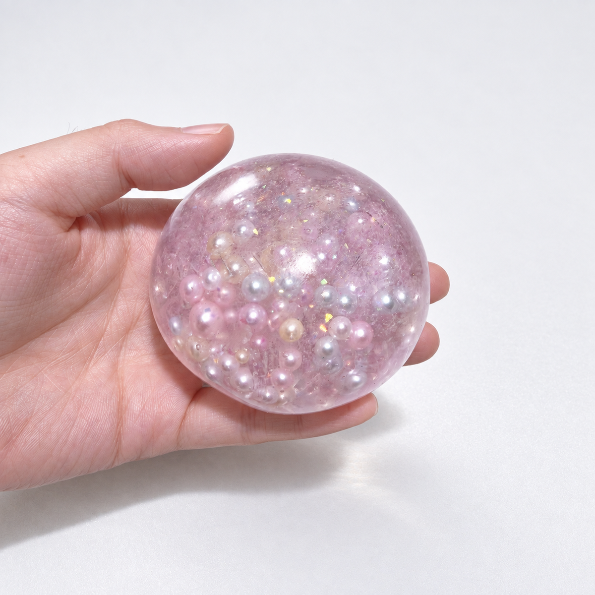 Pink translucent sensory squishy ball with resin pearl-like beads and iridescent details; Mermaid Pink Pearl handmade sensory squishy ball, product photo 4