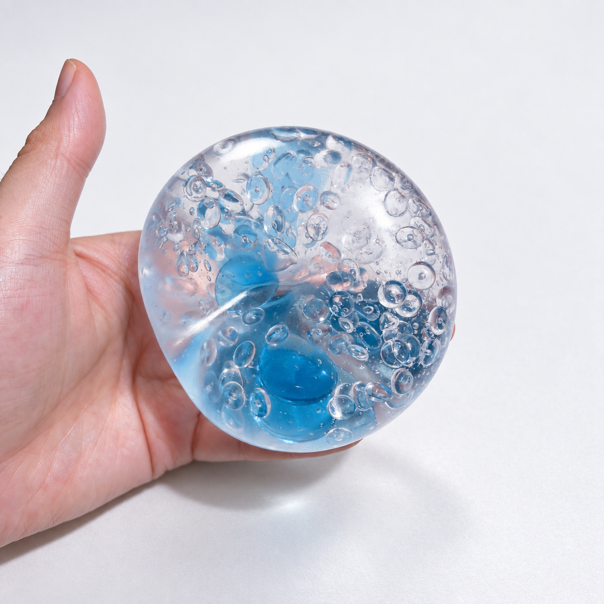 Clear pale-blue sensory squishy ball with blue and transparent resin bead details; Azure Water World handmade sensory squishy ball, product photo 2