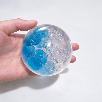 Clear pale-blue sensory squishy ball with blue and transparent resin bead details; Azure Water World handmade sensory squishy ball, product photo 4