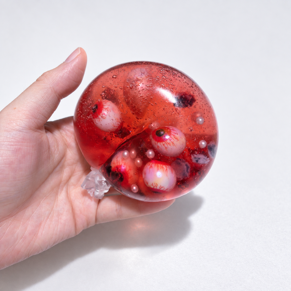 Red ball with multiple eyeball inclusions and small pearl accents