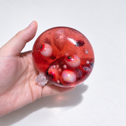 Red ball with multiple eyeball inclusions and small pearl accents