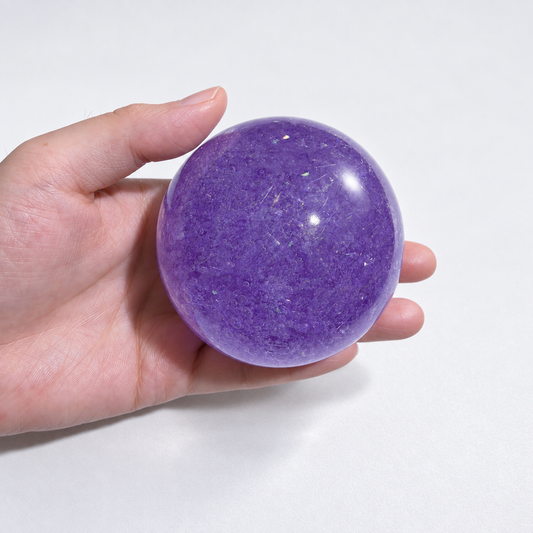 Purple translucent squishy ball with a crystal-inspired look held in a hand