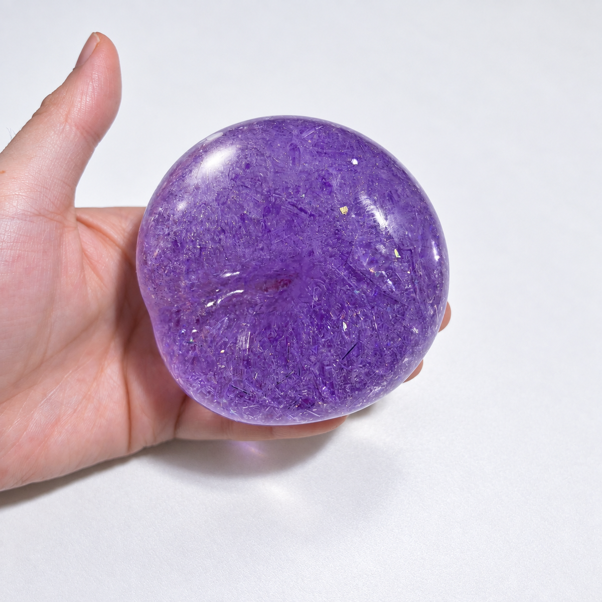 Purple sensory ball held in a hand, showing its translucent appearance